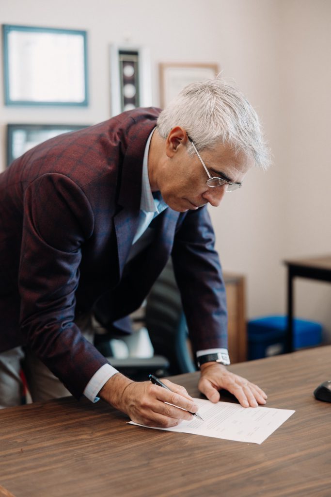 Luis Martínez revisando y firmando un documento